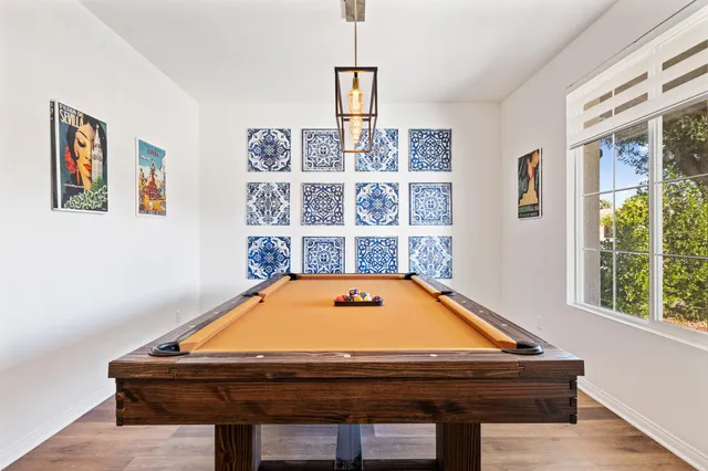 a kitchen with stainless steel appliances granite countertop a stove a sink dishwasher a dining table and chairs with wooden floor