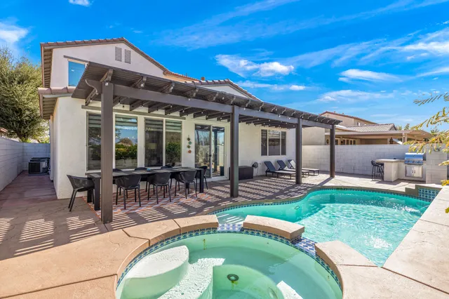 a view of a two chairs in the patio next to a yard
