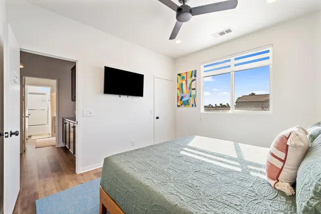 a bedroom with a bed and a painting on the wall