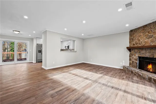 a view of empty room with wooden floor and fireplace