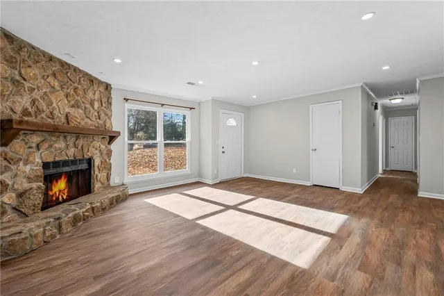 a view of empty room with wooden floor and fireplace