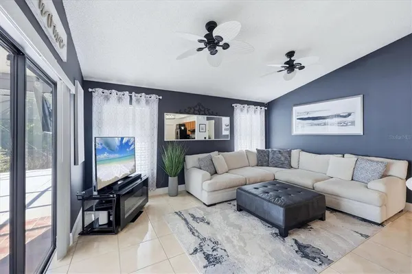a living room with furniture a ceiling fan and a window