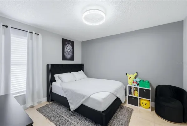 a bedroom with a bed a potted plant and a window