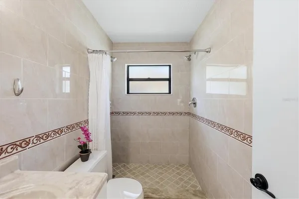 a bathroom with a shower a toilet and a shower