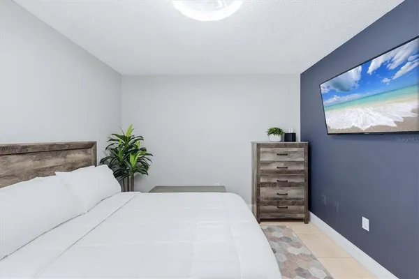 a bedroom with a bed and a flat screen tv