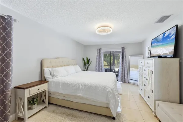 a bedroom with a bed and a flat tv screen in it