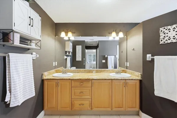 a bathroom with a granite countertop sink a vanity and a large mirror