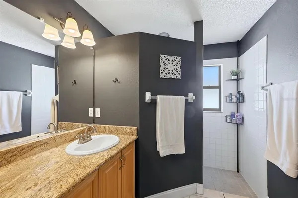 a bathroom with a granite countertop shower sink and toilet