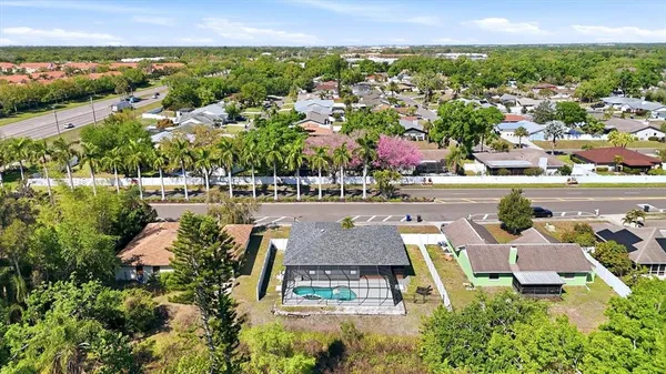 an aerial view of residential houses with outdoor space and trees