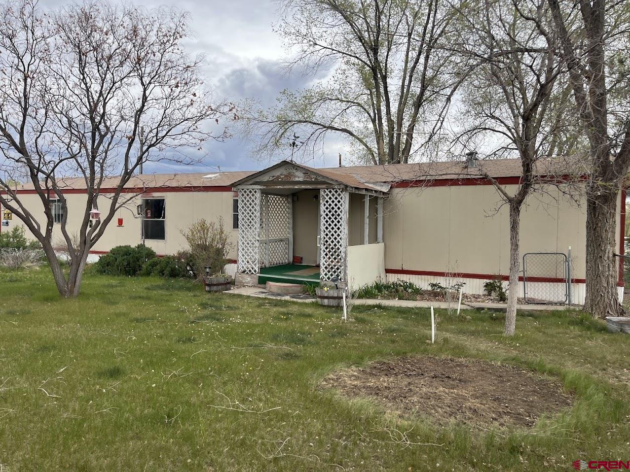 a backyard of a house with barbeque oven and table and chairs