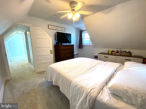 a bedroom with a bed and a flat tv screen on dresser