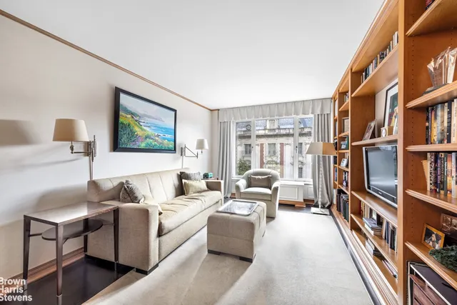 a living room with furniture a bookshelf and a book shelf