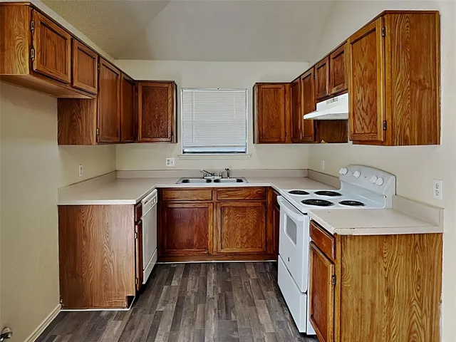 a kitchen with a sink stove top oven and cabinets