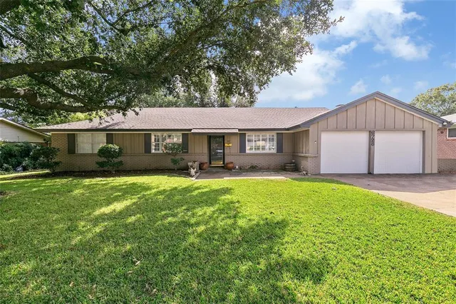 a front view of a house with a garden and yard
