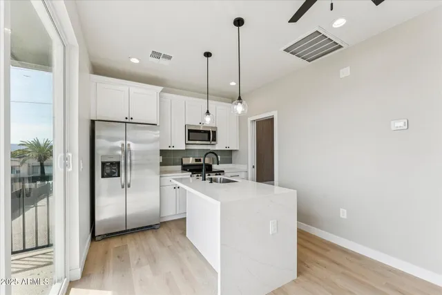 a kitchen with stainless steel appliances a refrigerator a sink and a stove