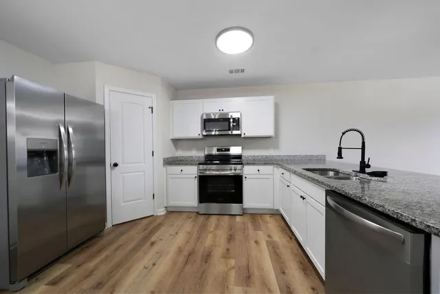 a kitchen with granite countertop a stove top oven and sink