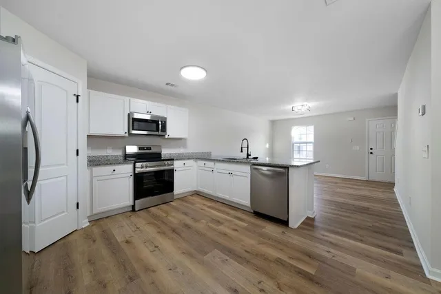 a kitchen with a refrigerator a stove top oven a sink and dishwasher