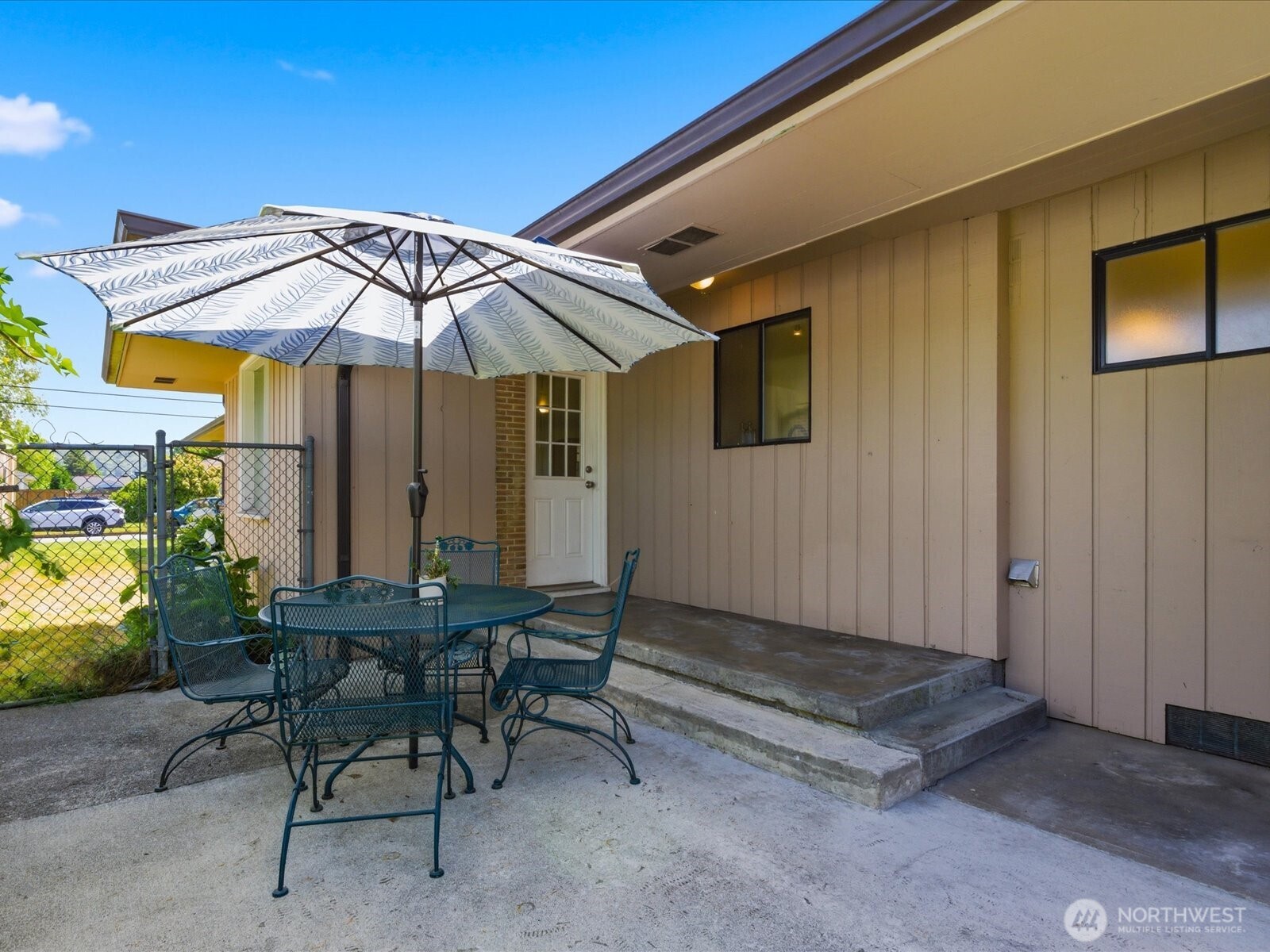1417 Maple Street Sumner, WA 98390 - Photo 39 of 40 a patio with a table and chairs under an umbrella