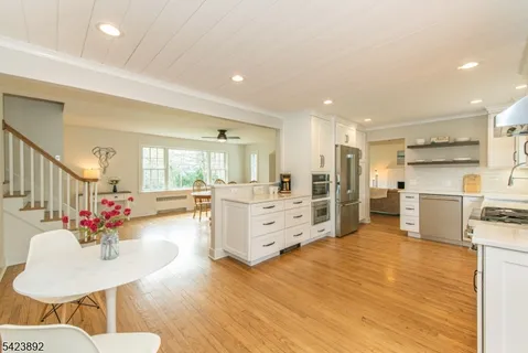 a open kitchen with white cabinets and stainless steel appliances