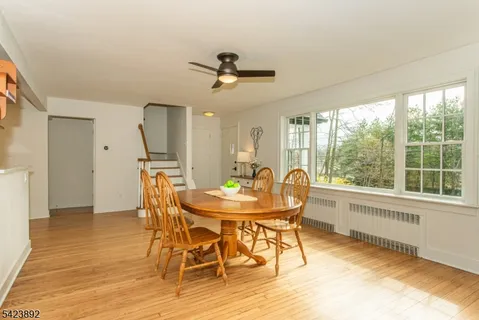 a dining room with furniture a chandelier and wooden floor