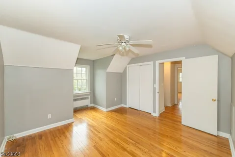 a view of a room with wooden floor and ceiling fan
