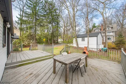 swimming pool view with large trees and wooden floor