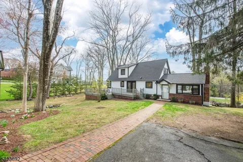 a view of a house with a large tree in front of it