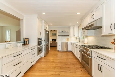 a large kitchen with stainless steel appliances double vanity and a stove