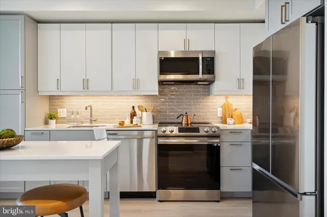 a kitchen with stainless steel appliances a stove a sink and a microwave