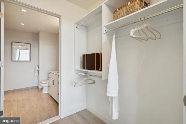 a view of a hallway with bathroom and wooden floor