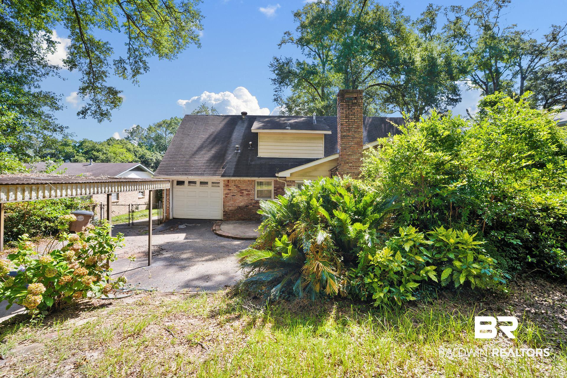 576 Markham Drive Mobile, AL 36609 - Photo 18 of 18 View of back of home with a chimney, an attached garage, and brick siding