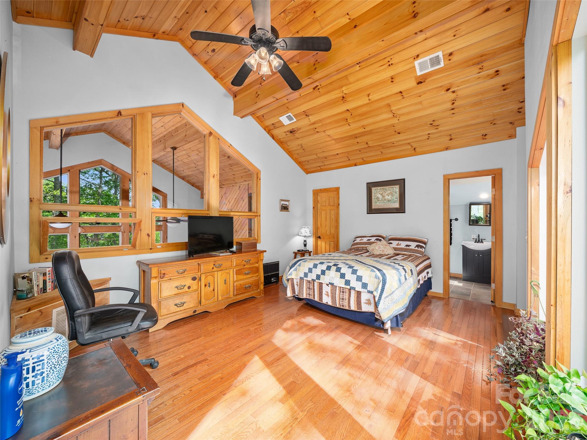 228 Continental Divide Road Spruce Pine, NC 28777 - Photo 19 of 48 a spacious bedroom with a bed a flat screen tv and balcony view