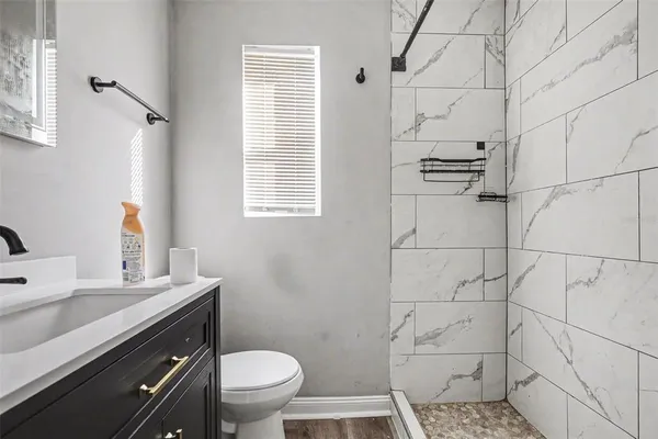 a bathroom with a sink a toilet and shower