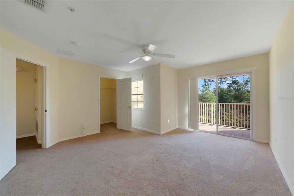 851 Assembly Court Kissimmee, FL 34747 - Photo 17 of 27 an empty room with chandelier fan and windows