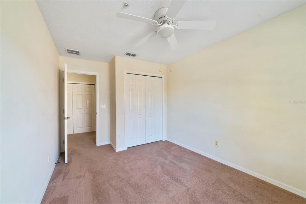 851 Assembly Court Kissimmee, FL 34747 - Photo 24 of 27 an empty room with a ceiling fan and a window