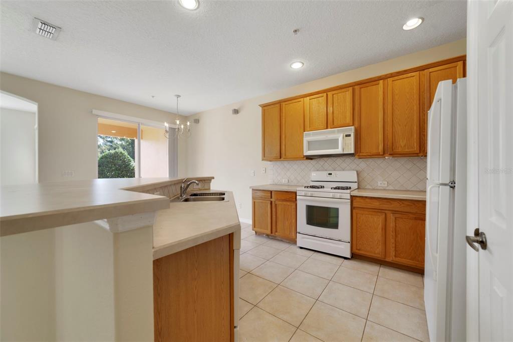 851 Assembly Court Kissimmee, FL 34747 - Photo 6 of 27 a kitchen with stainless steel appliances a stove sink and cabinets