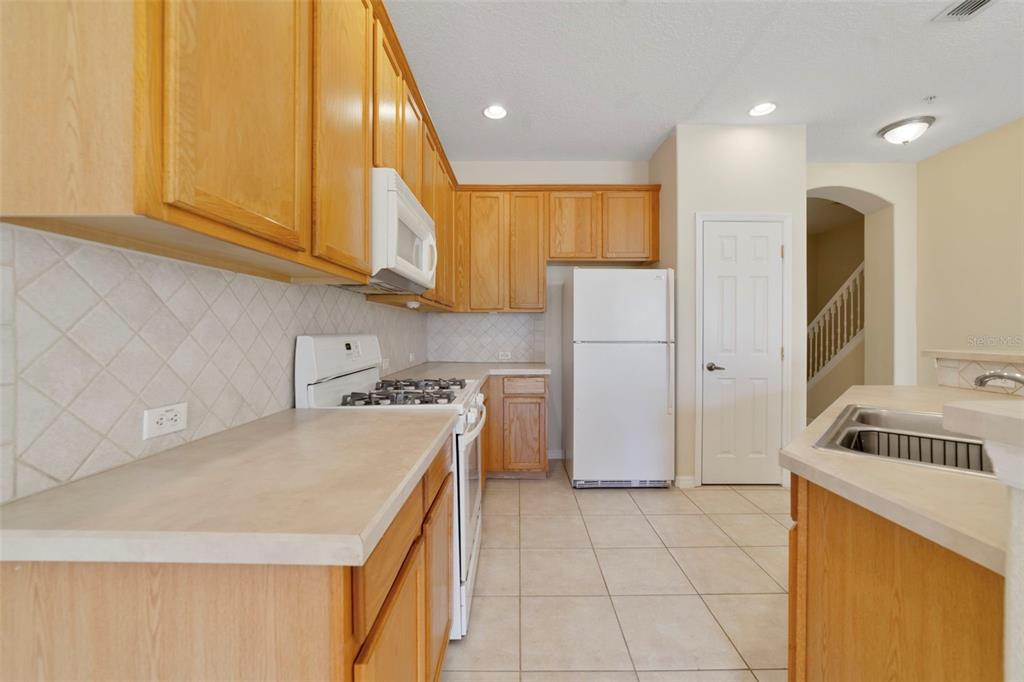 851 Assembly Court Kissimmee, FL 34747 - Photo 9 of 27 a kitchen with a sink a refrigerator and cabinets