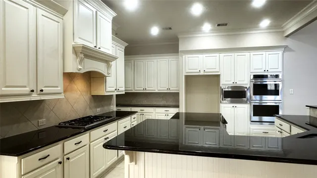 a kitchen with kitchen island granite countertop a sink a stove and a refrigerator