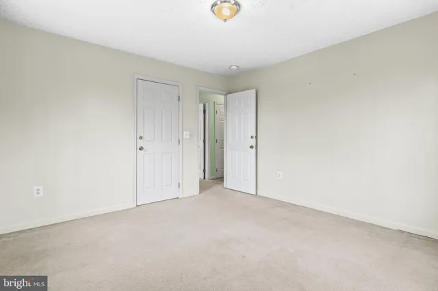 an empty room with windows and ceiling fan