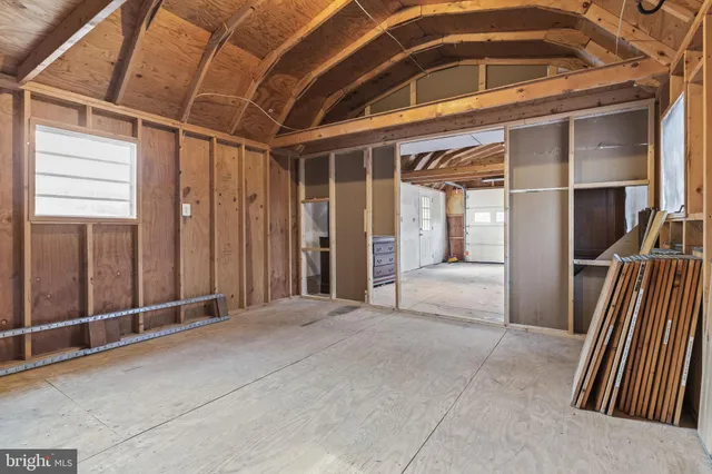 a white house with a large tree in front of a white house