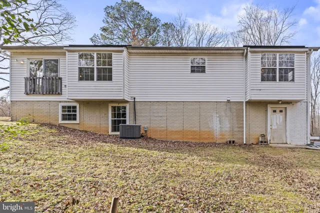 a view of a large house with a large tree and a yard