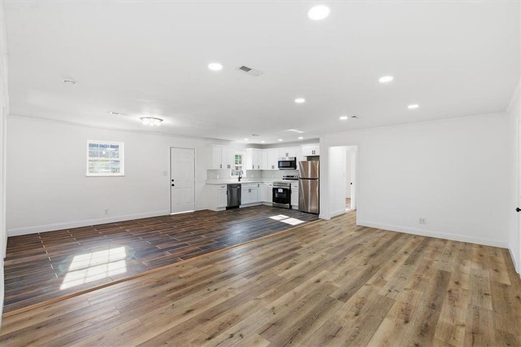 130 Malone Drive Rome, GA 30165 - Photo 6 of 45 an empty room with wooden floor kitchen view and a window