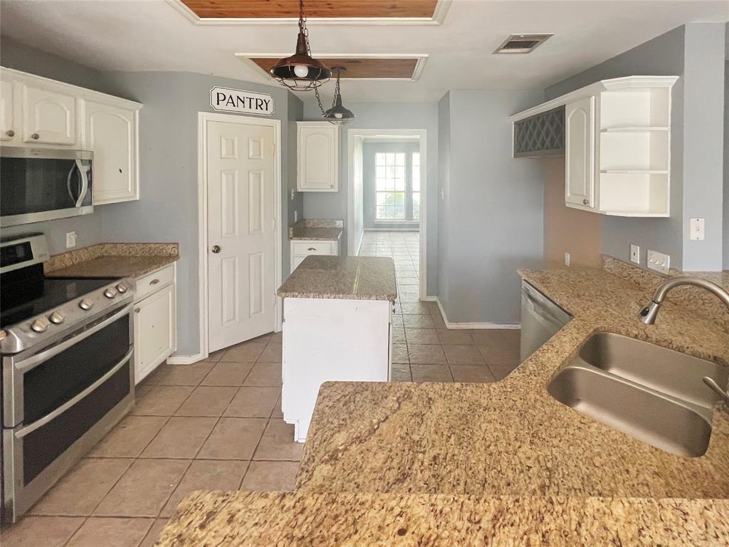 3661 Emo Street Midlothian, TX 76065 - Photo 5 of 24 a kitchen with stainless steel appliances granite countertop a sink stove and refrigerator