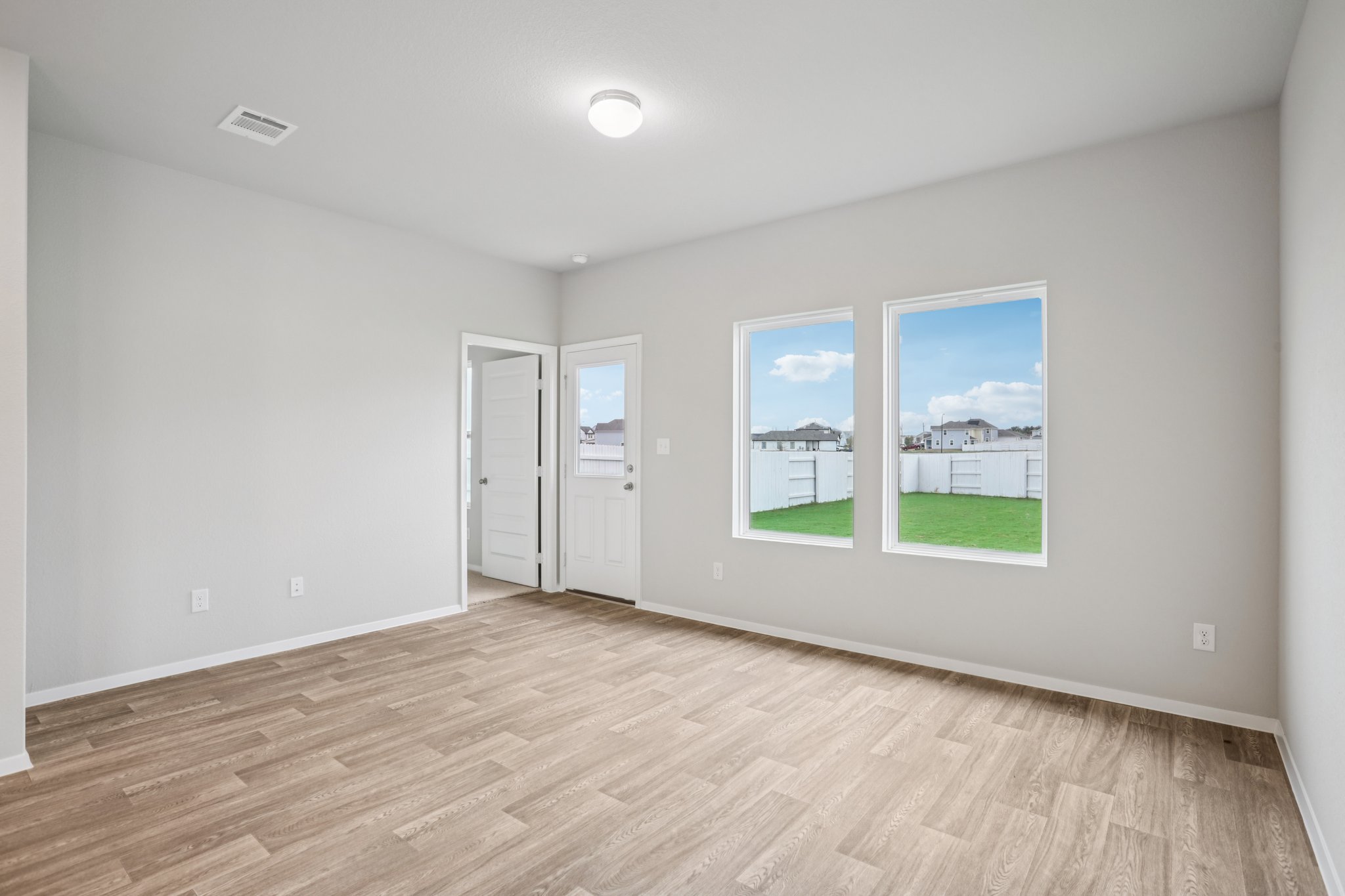 104 Summer Drive Elgin, TX 78621 - Photo 16 of 40 an empty room with wooden floor and windows