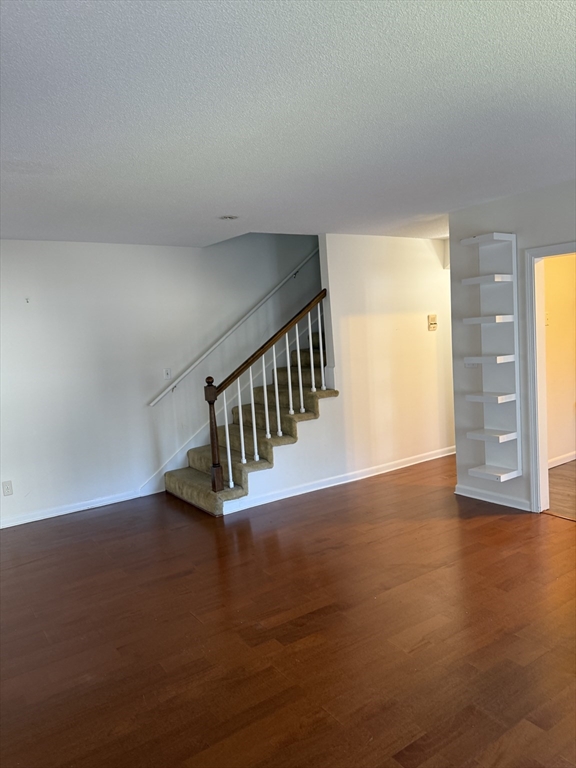 577 Adams Street, Unit D Milton, MA 02186 - Photo 7 of 11 a view of an empty room with wooden floor and windows
