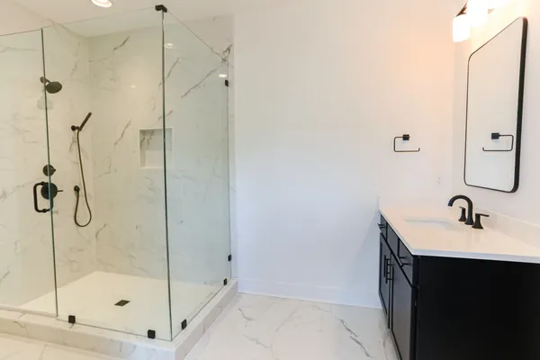 a bathroom with a shower sink and mirror