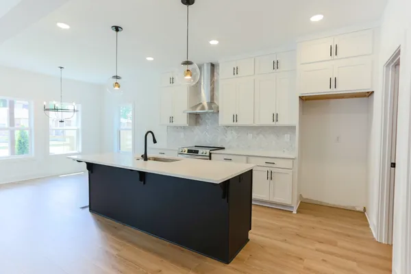 a kitchen with kitchen island granite countertop a sink cabinets and wooden floor