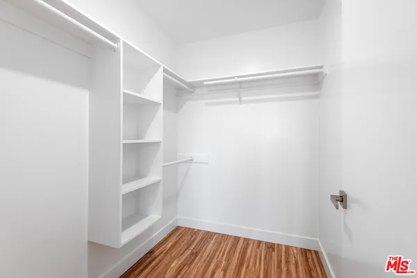 a view of walk in closet with empty racks