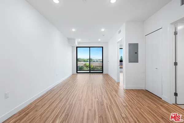 a view of a room with wooden floor and window