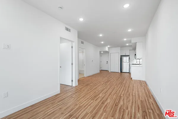 a view of empty room with wooden floor
